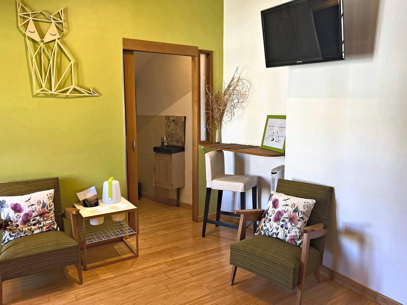 The sitting area in En Messepierre, with two armchairs and the television