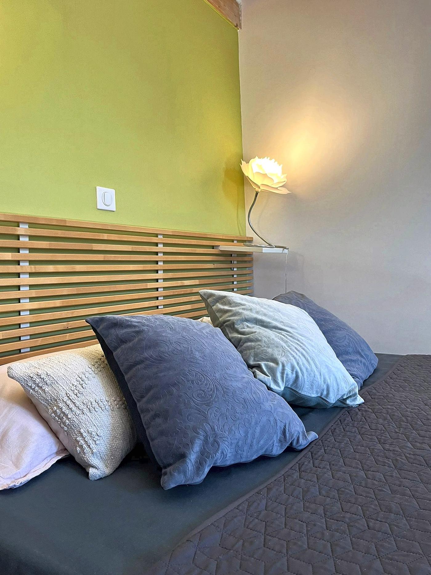 The bed in Les Terrasses and its slatted wooden headboard