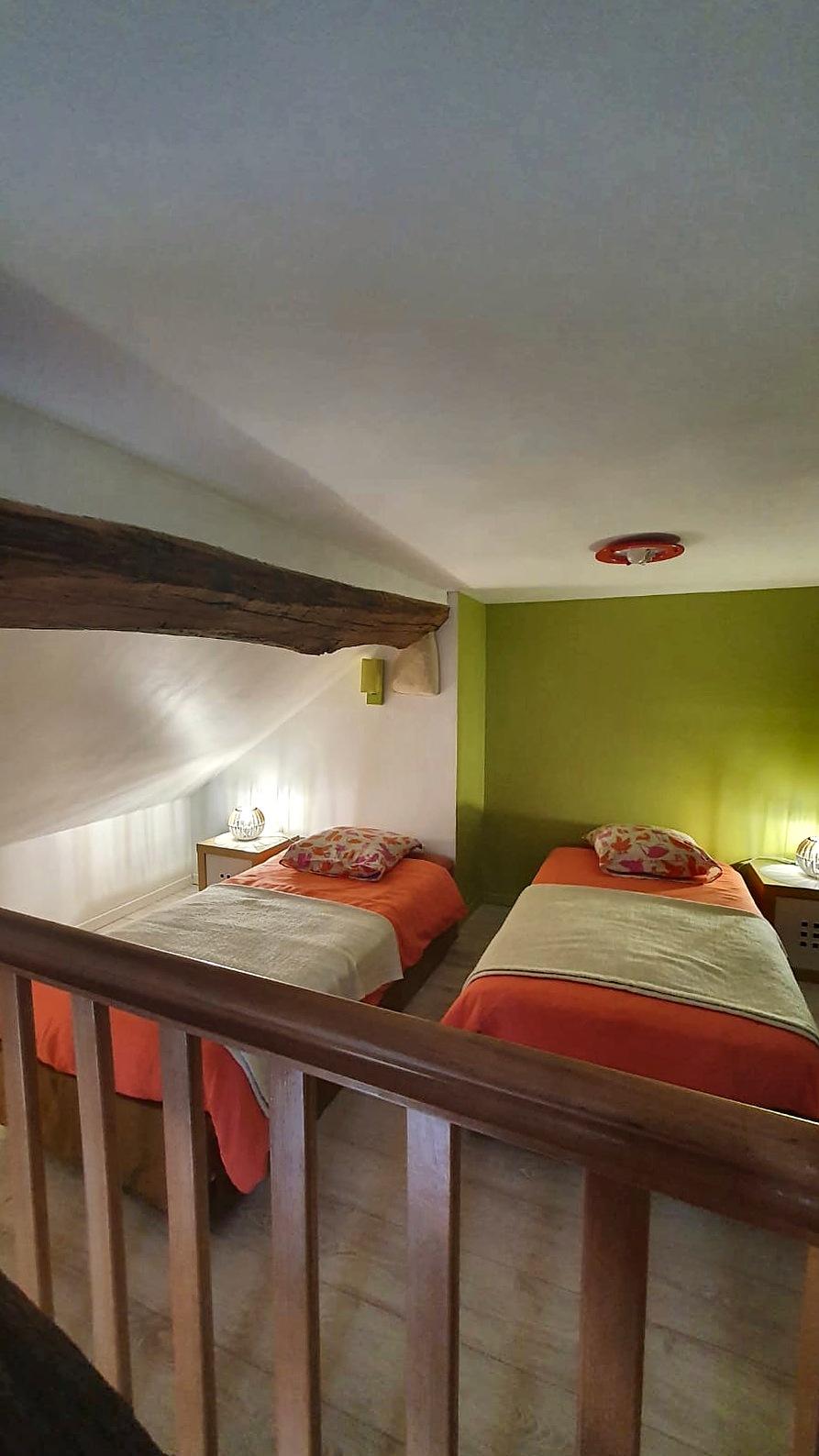 The mezzanine in Les Terrasses, its two single beds and lime-green wall