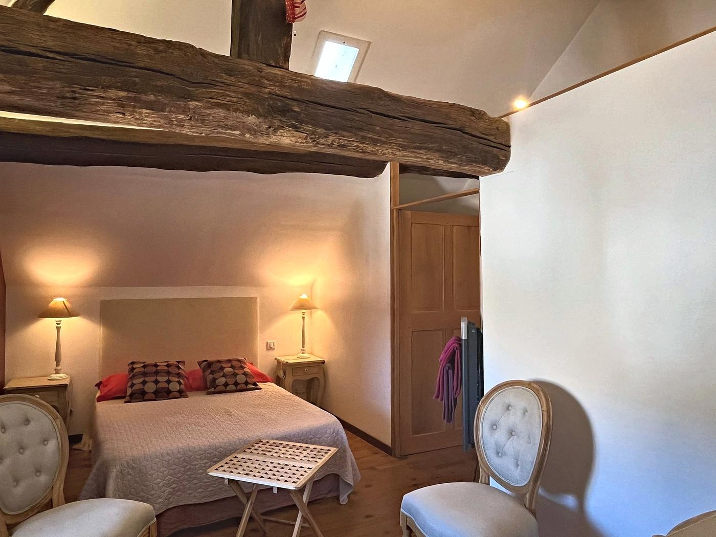 Le Colombier bedroom, its exposed beams and double bed