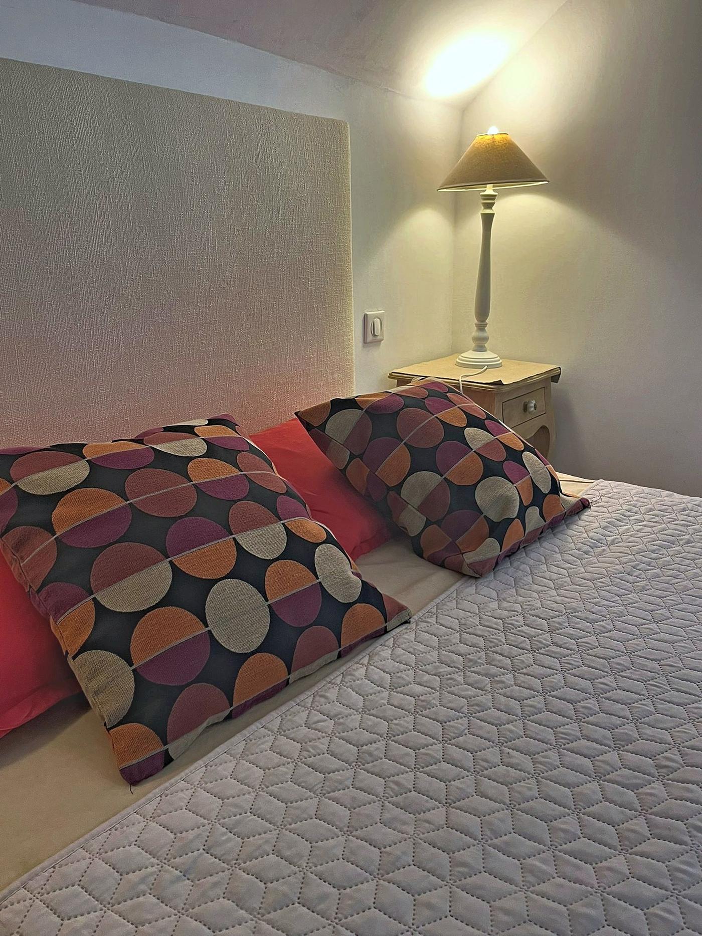 The bed in Le Colombier and its patterned cushions
