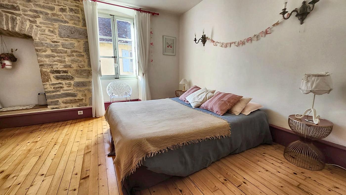 Le Chanaie bedroom: its double bed, stone wall and wooden floor