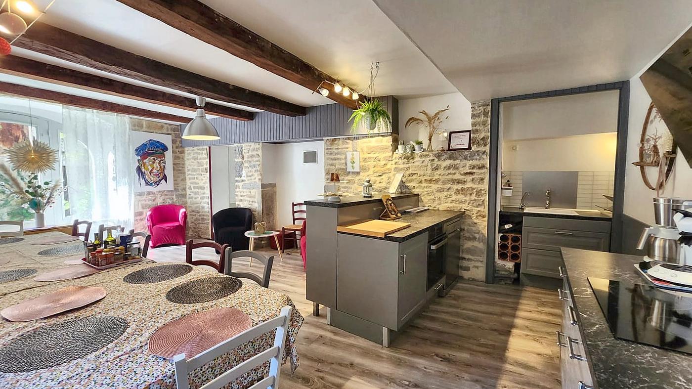 The dining room in one long sweep: the big table, the kitchen island and the scullery at the far end