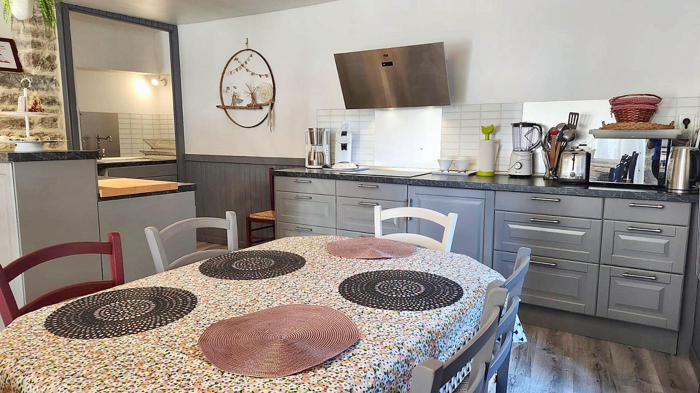 The dining table in front of the kitchen’s grey cabinets