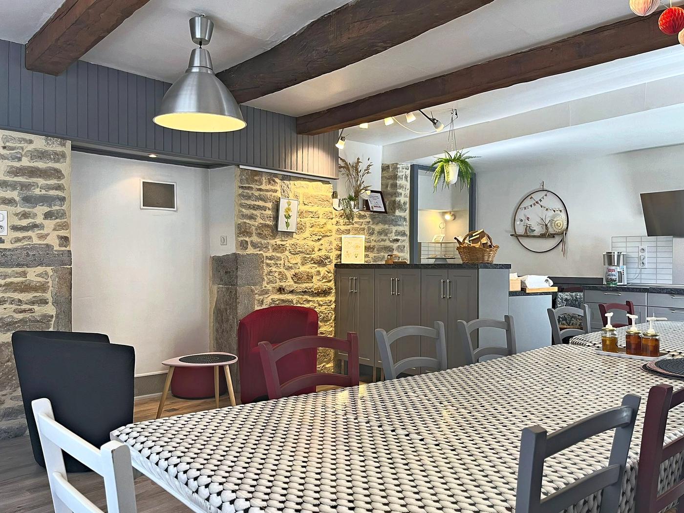 The long dining table, under the beams and against the stone wall
