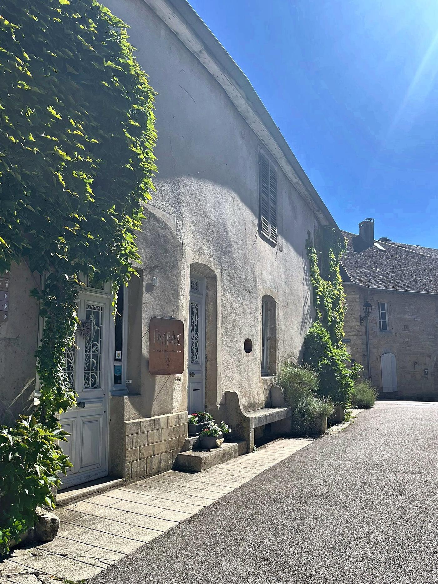 The stone front of the house, covered in Virginia creeper, on the village lane