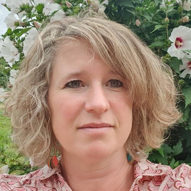 Marie Boyer, your host at T’Nature, in front of a flowering hibiscus