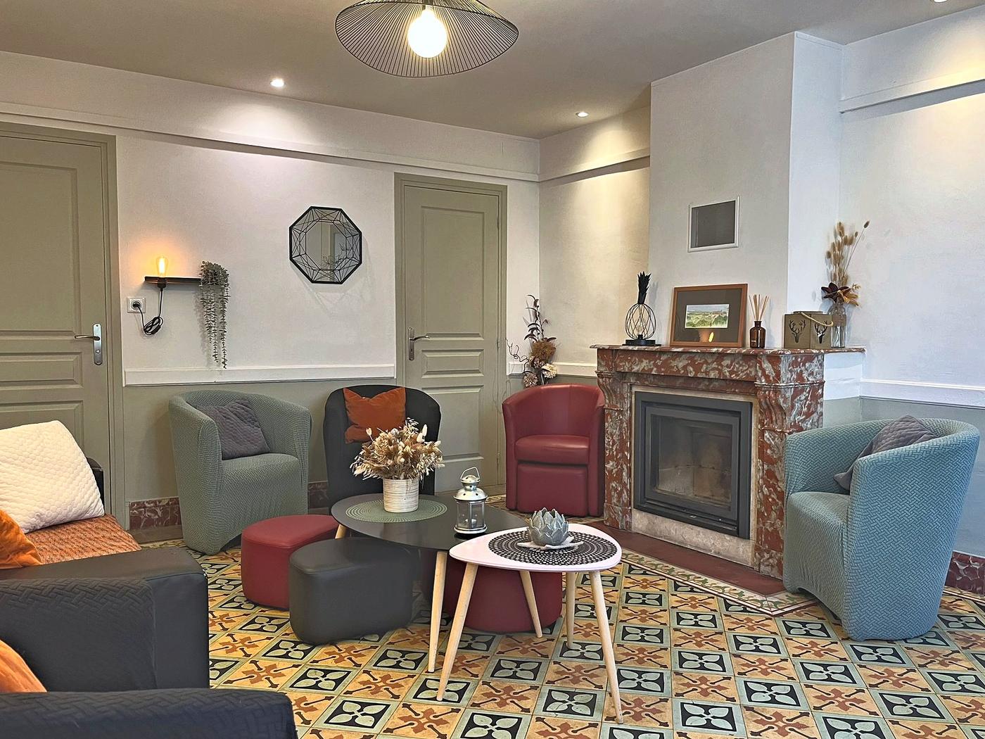 The sitting room: armchairs, a marble fireplace and original cement-tile floors