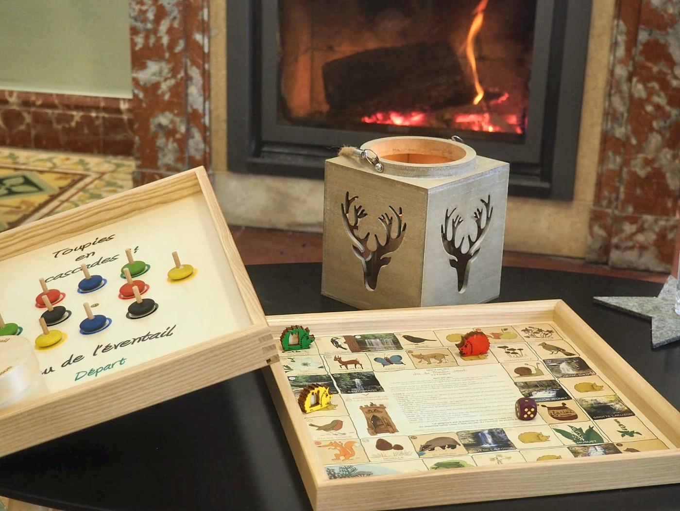 Wooden games on the sitting-room coffee table, in front of the lit fireplace